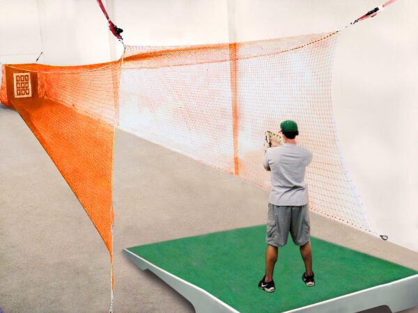 A man is swinging at an orange net.